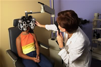 Description: Optometrist using a phoropter and retinoscope